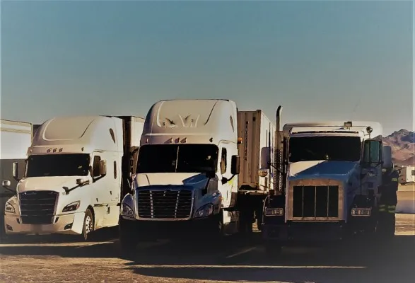 Tres trailers blancos alineados en el desierto, capturando la esencia, todos equipados con un jammer bloqueador de señal